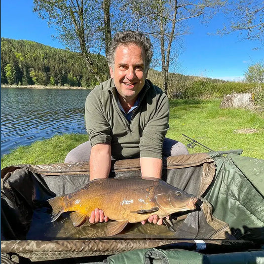 Angler mit Fisch am See – echte Praxis beim Angeln