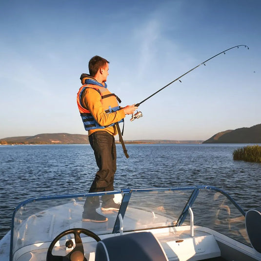 Angler steht im Wasser mit Fisch – erfolgreicher Fang